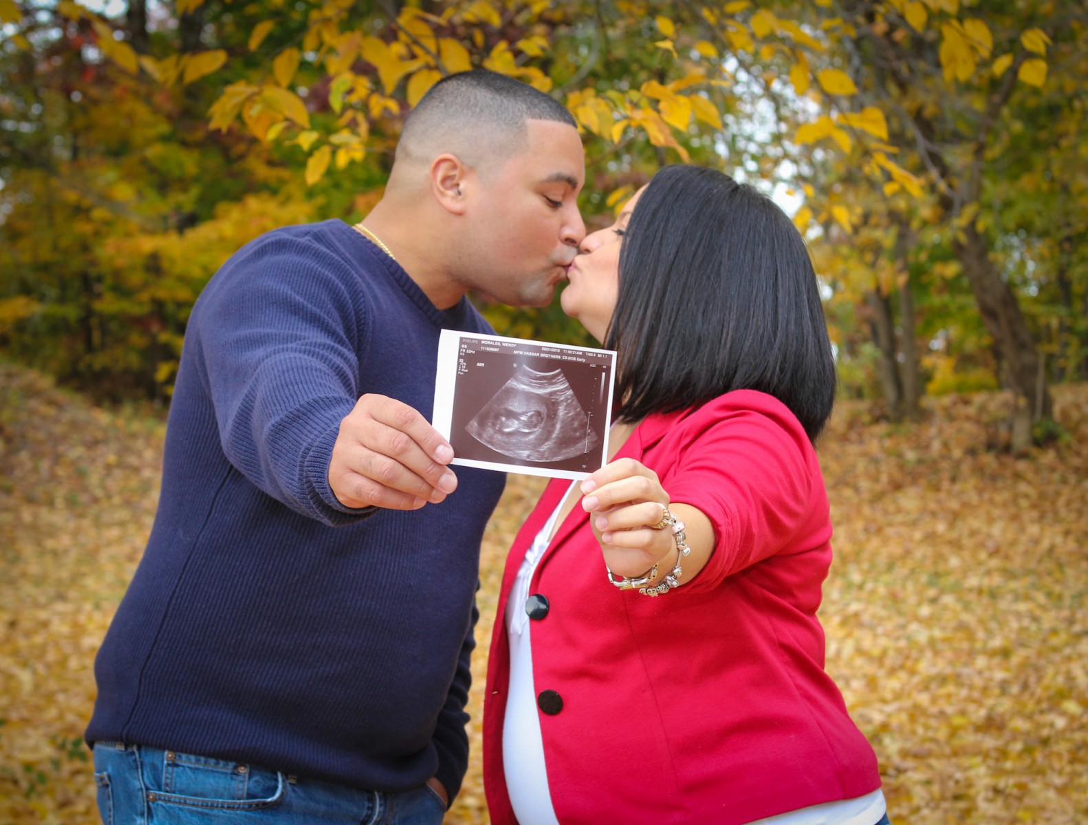 couple kissing holding sonogram
